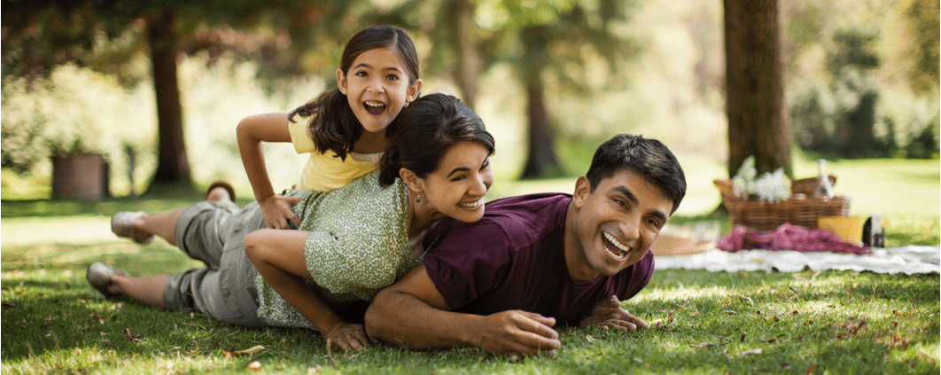 family lying in grass laughing